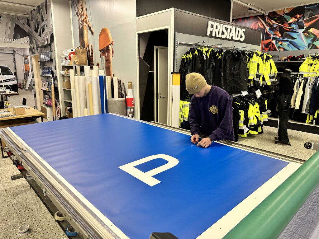 Pysäköintikyltin teippaus työpajassa